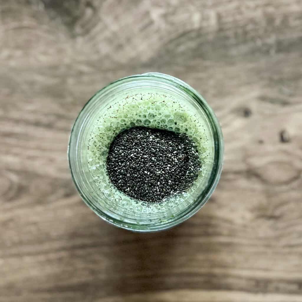 Chia seeds added to the jar with matcha mixture.