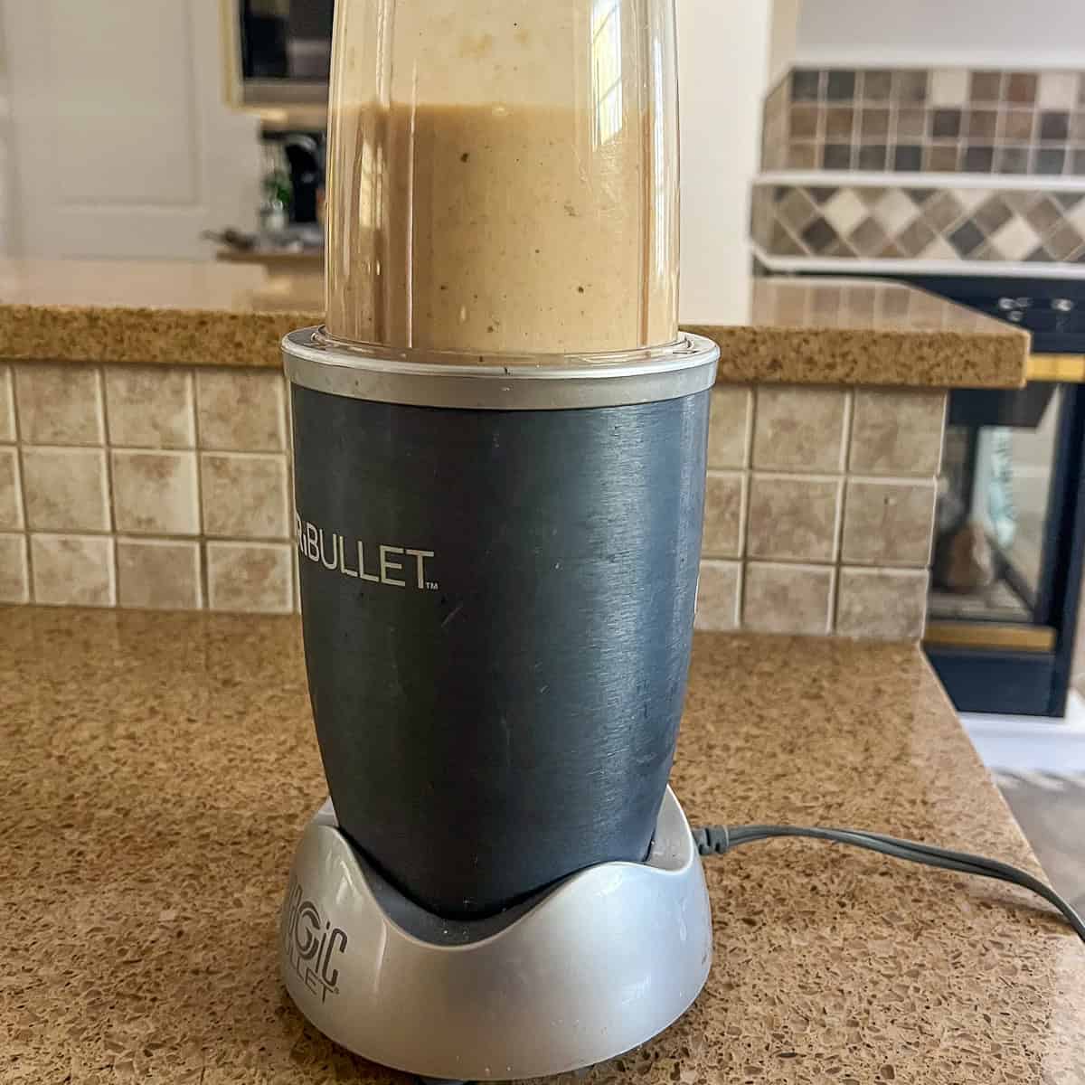 Cream mixture being blended in a bullet blender cup.