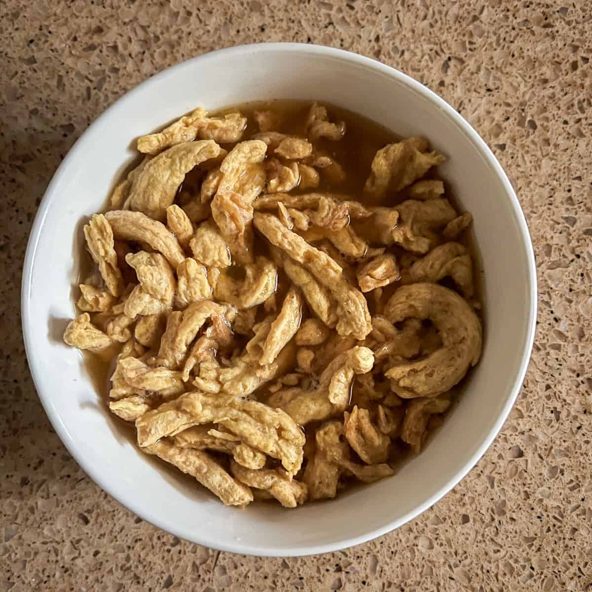 Soy curls soaking in vegetable broth.