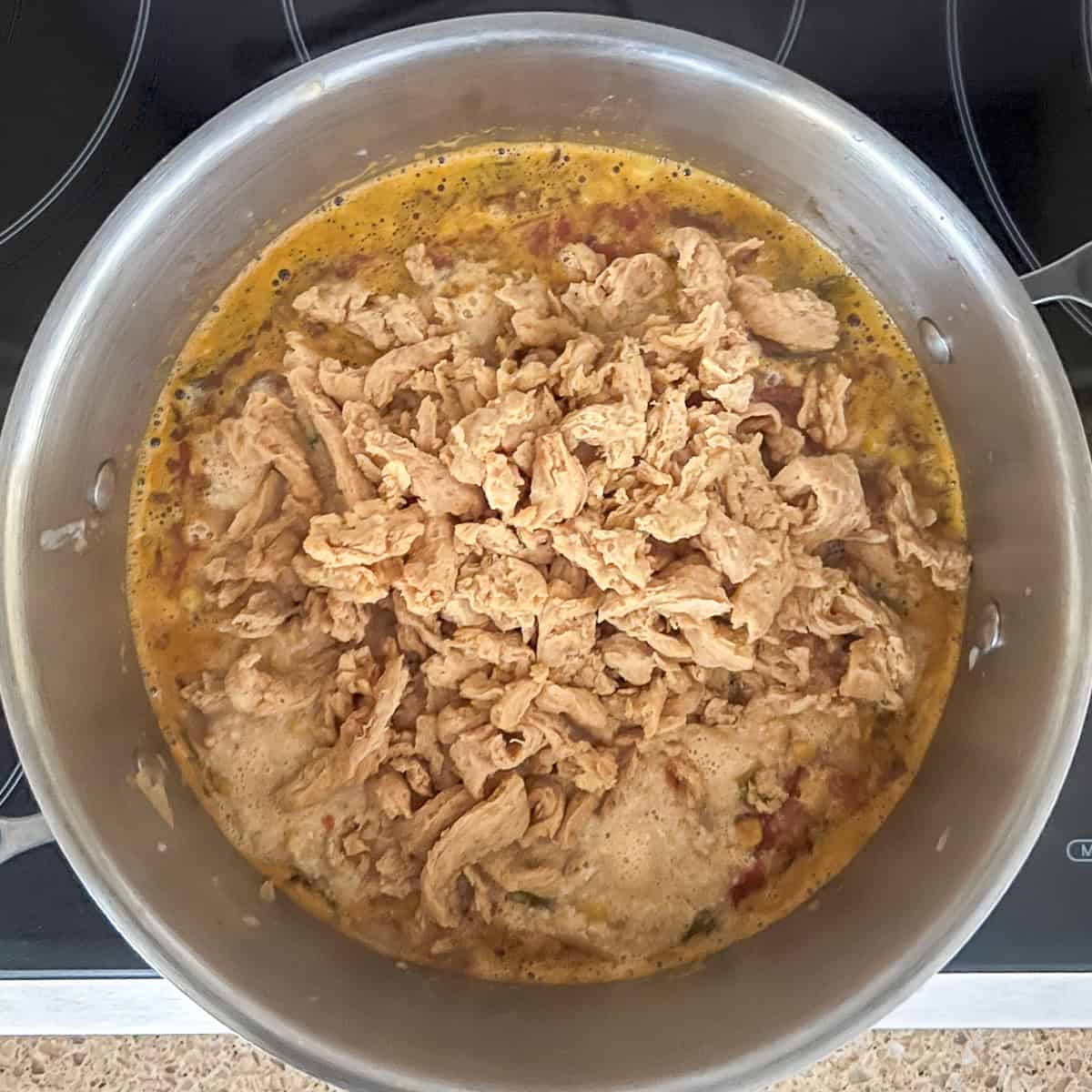 Soy curls with broth added to the soup pot.