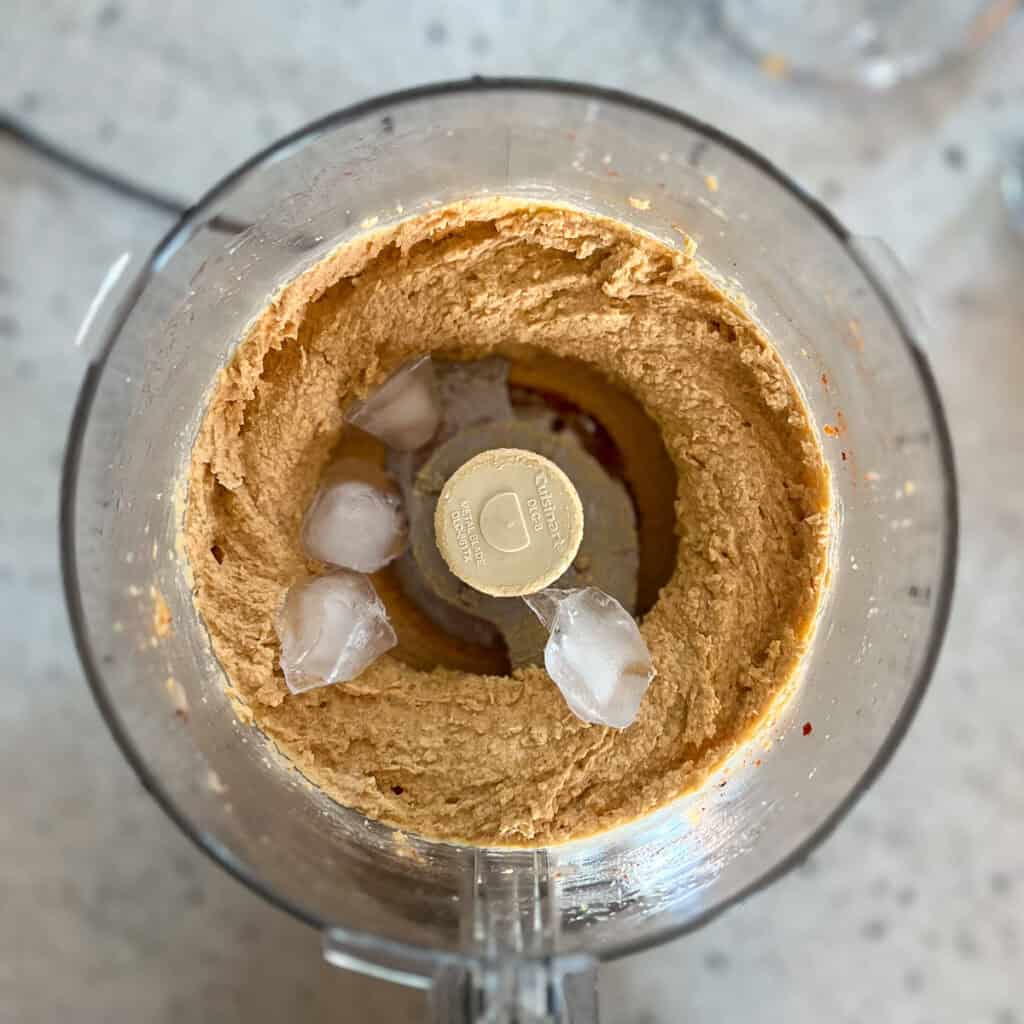 Ice cubes added to the harissa hummus in the food processor.