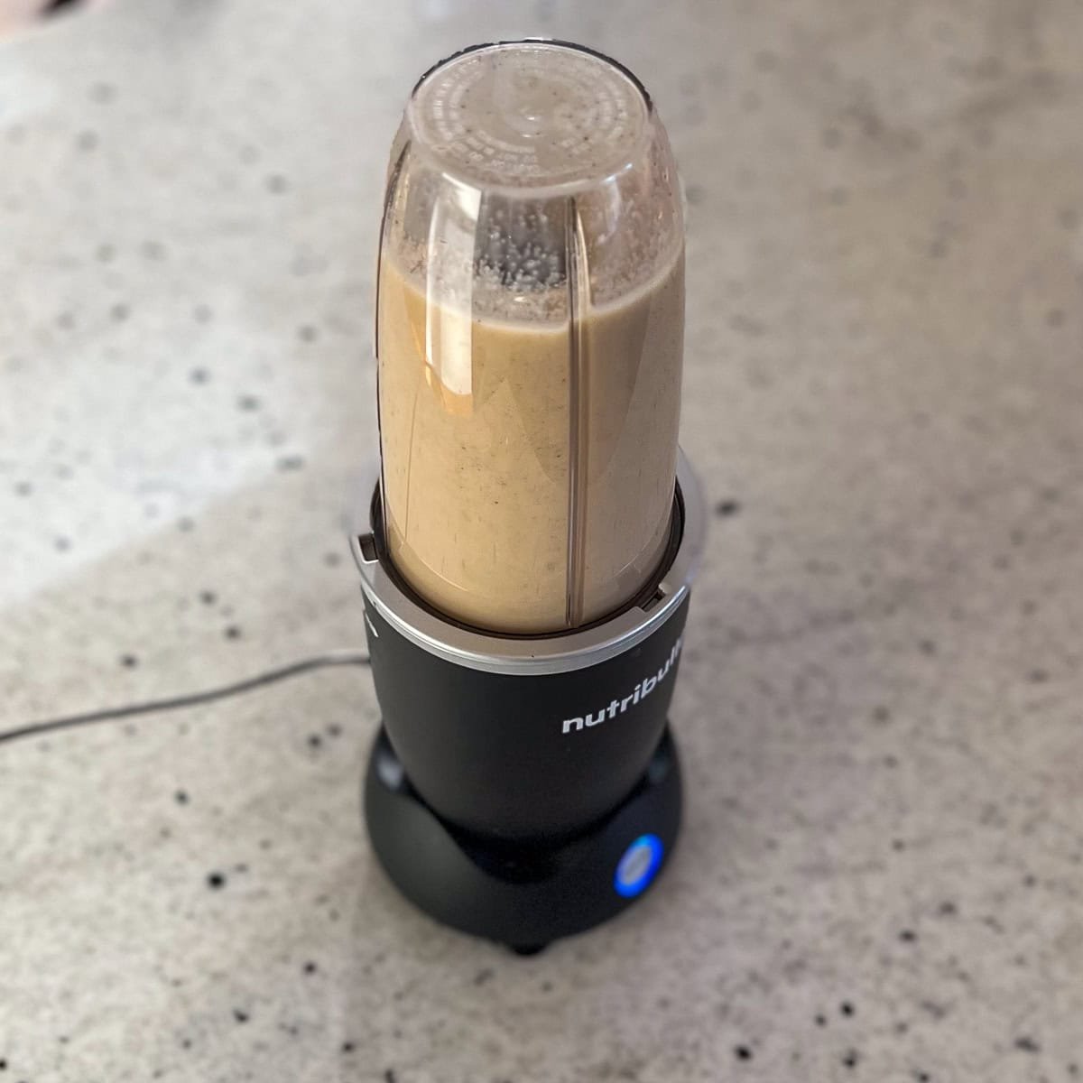 Vegan eggnog mixture being blended in a high speed bullet blender.