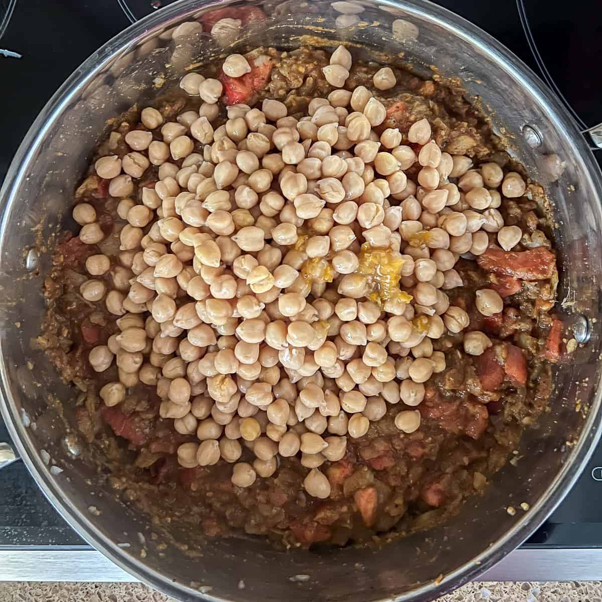 Chickpeas added to the pan with other ingredients.