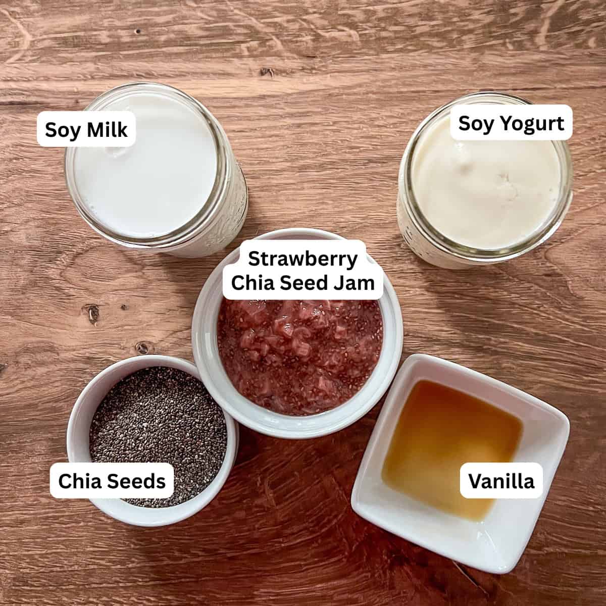 Ingredients for chia strawberry pudding: soy milk, soy yogurt, strawberry chia jam, vanilla and chia seeds.