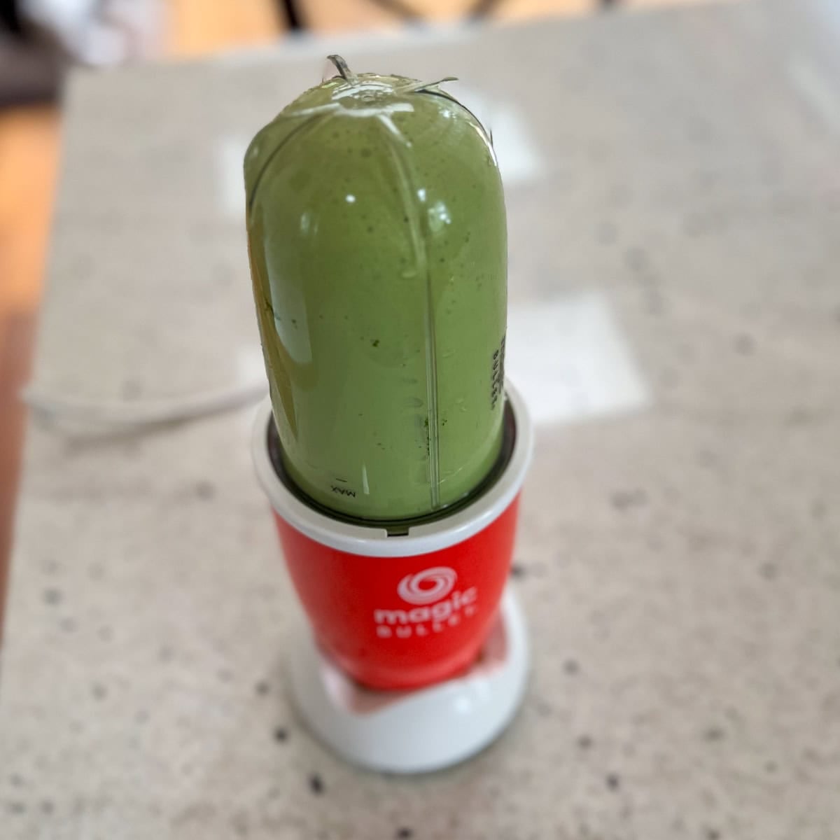 Matcha and soy milk being blended in a bullet blender.