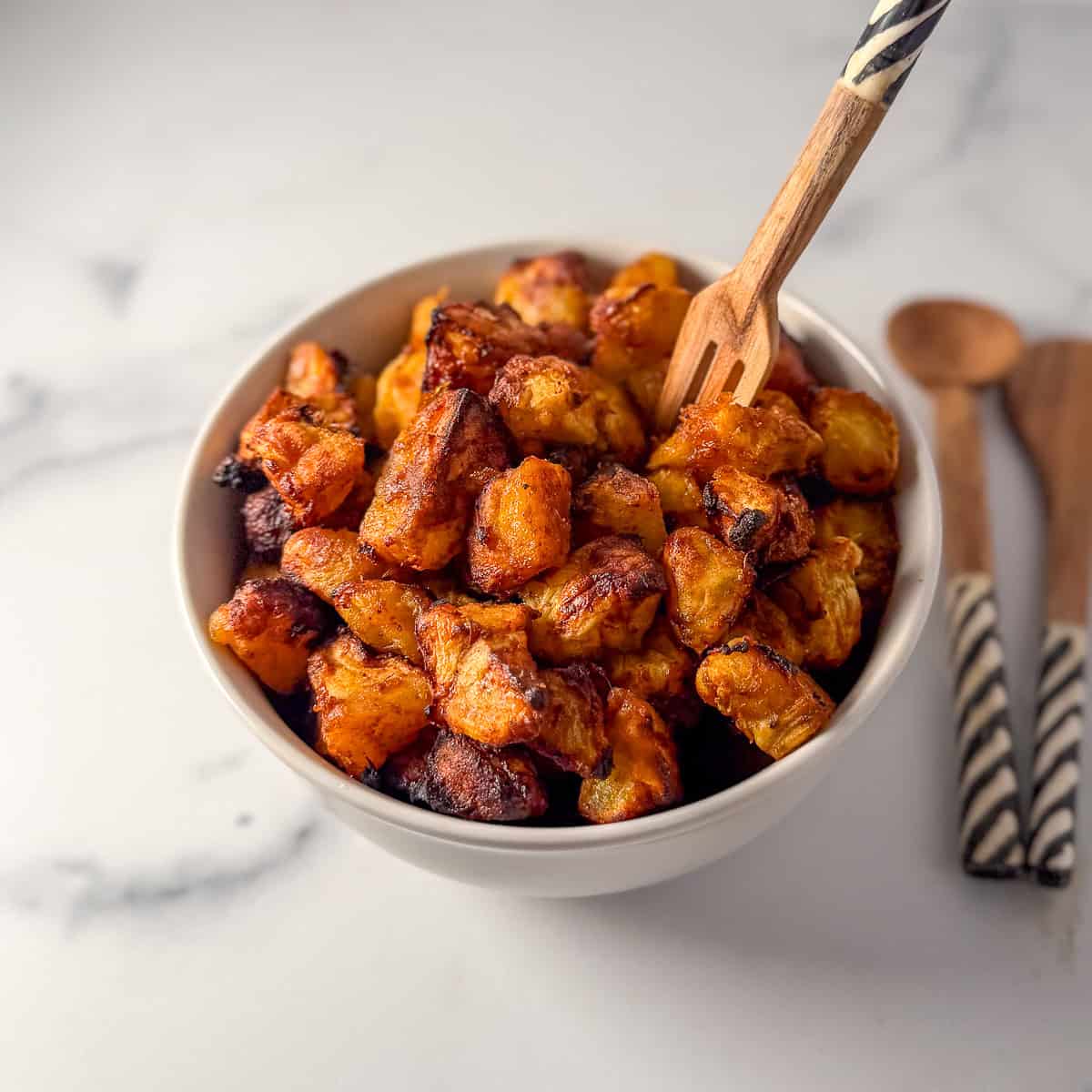 Air fryer kelewele in a bowl with a decorative fork.