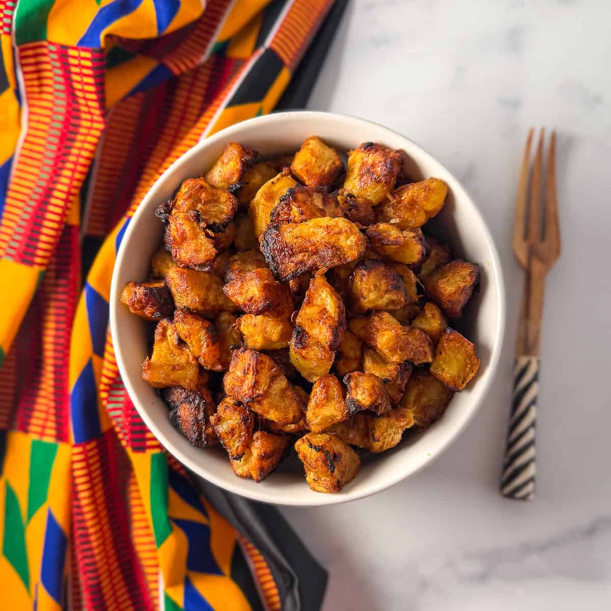 A bowl of air fryer kelewele with a fork on the side.