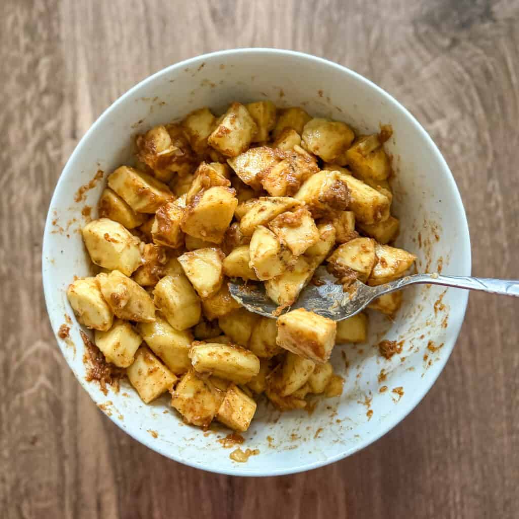 Plantains being tossed in spice mixture to coat.