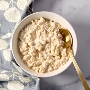 A bowl of vegan cottage cheese with a spoon.