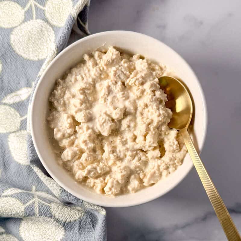 A bowl of vegan cottage cheese with a spoon.