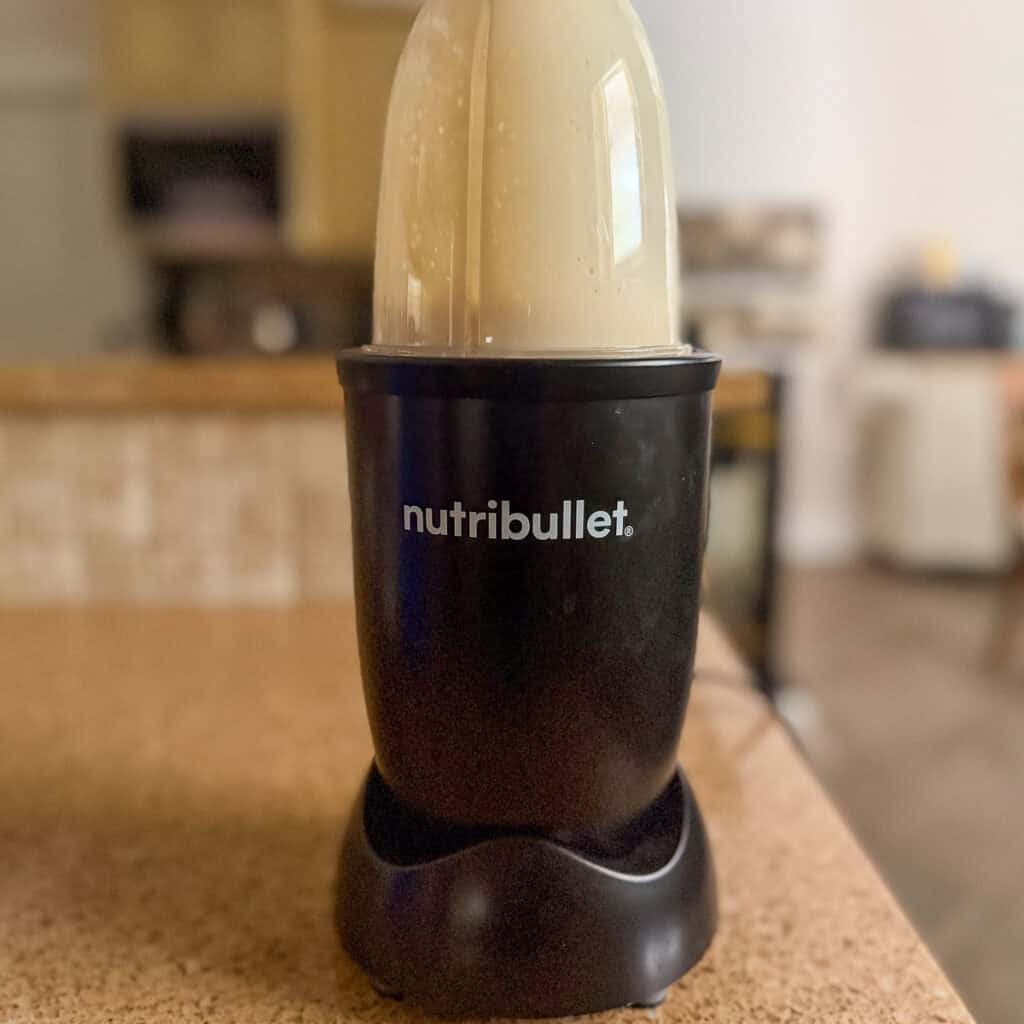 Silken tofu and seasonings being blended in a bullet blender.