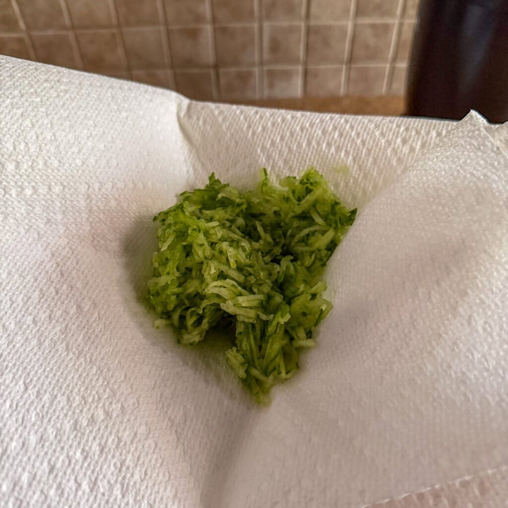 Grated cucumber in a paper towel to remove excess liquid.