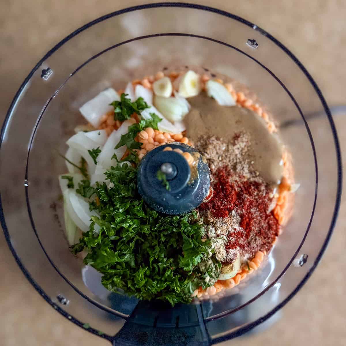 Red lentil mixture ingredients in a food processor.