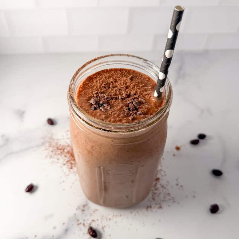 Chocolate black bean smoothie in a mason jar with a straw.
