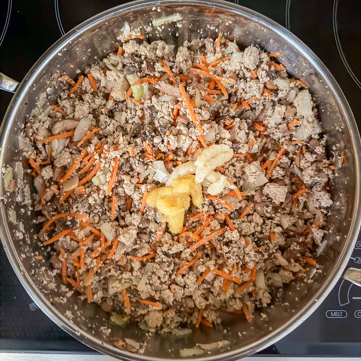 Garlic and ginger added to the cooked mixture in the large saute pan.